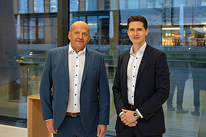 Two person are staying in a foyer of a business building